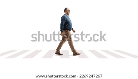 Full length profile shot of a mature man crossing street on a pedestrian sign isolated on white background