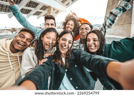 Happy multi ethnic young people taking selfie photo with smart mobile phone outside - Life style concept with guys and girls having fun hanging out on city street - Youth community concept