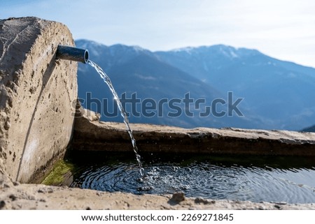 A water tap in the mountains. Village fountain. Natural spring water.