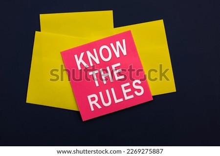Know the rules - inscription of a pink square sticky note paper on dark background. Top view. Business, tips and tricks concept