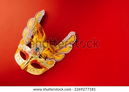 Happy Purim carnival. Carnival mask for Mardi Gras celebration isolated on red background banner design with copy space, jewish holiday, Purim in Hebrew holiday carnival ball, Venetian mask