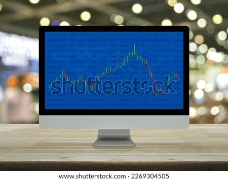 Trading graph of stock market with world map and graph on computer screen on table over blur of shopping mall, Business investment online concept, Elements of this image furnished by NASA