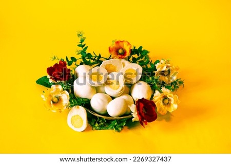 Easter picture with cupcakes in the form of Easter eggs,on a yellow background in a basket with flowers.Baking in the form of eggs covered with white chocolate,a fashionable alternative to Easter cake
