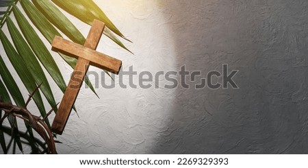 Crown of thorns, wooden cross and palm leaf on light background with space for text. Good Friday concept