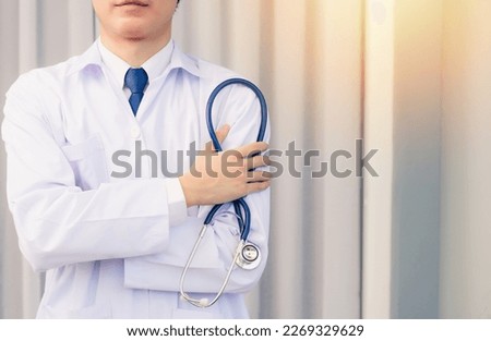 Doctor Day. Nurse man smiling in uniform stand crossed arm hold doctor stethoscope on hand looking to camera with cop space, Healthcare medicine insurance concept Royalty-Free Stock Photo #2269329629