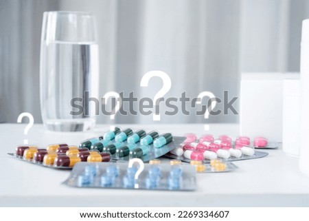 using medicine incorrectly or take wrong dose medicine concept with   pills and glass of water with question mark  Royalty-Free Stock Photo #2269334607