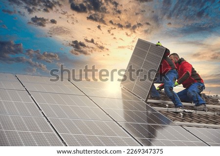 Installing solar photovoltaic panel system. Solar panel technician installing solar panels on roof. Alternative energy ecological concept. Royalty-Free Stock Photo #2269347375