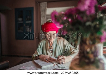 Woman writes a letter sitting in her living room