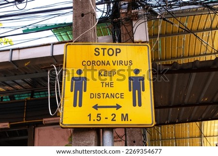Old Yellow signs inform STOP CORONA VIRUS KEEP THE DISTANCE 1.5-2 M due to COVID-19 in famous Chatuchak Market in Thailand. Stores, offices, other public places temporarily Economy hit by corona virus