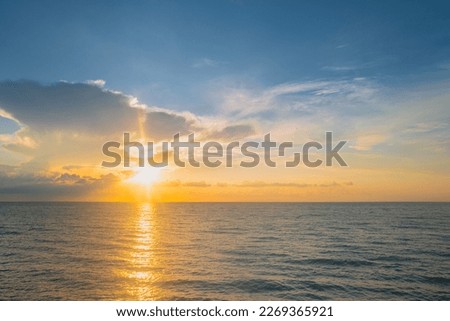 Sunset sea landscape. Colorful beach sunrise with calm waves. Nature sea sky. Sunrise with clouds of different colors against the blue sky and sea. Ocean and sky background, seascape.