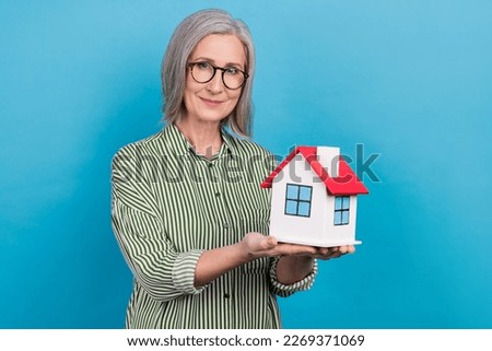 Portrait of nice positive person arms hold little house miniature isolated on blue color background