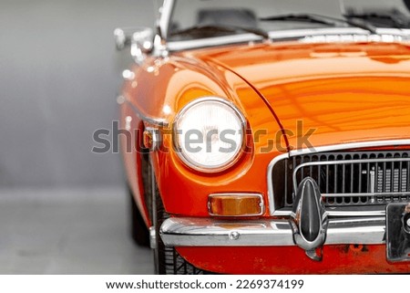 the shining front light of a red historic convertible Royalty-Free Stock Photo #2269374199