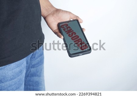 man looking at cellphone screen and censored writing on screen