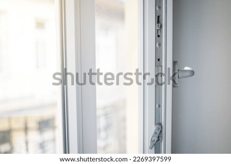 White plastic window frame with fittings close-up. Upvc windows and doors accessories and hardware. Royalty-Free Stock Photo #2269397599