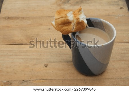 a cup of coffee with a piece of bread on top of the cup