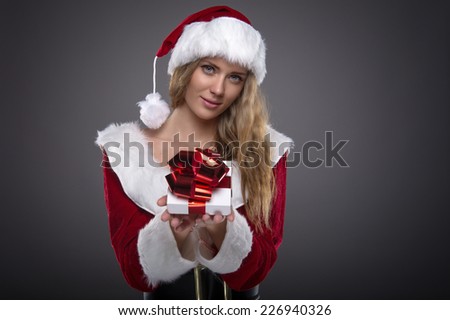 Beautiful young girl in a Christmas costume. New Year's holidays. Woman celebrating Christmas. Gift box