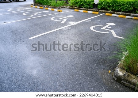 White handicapped symbol painted on asphalt floor special lane parking. Disabled parking spaces. traffic sign about handicaps