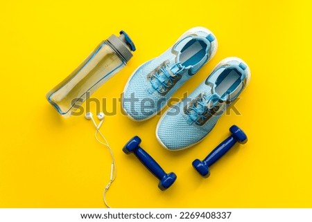 Sport fitness flatlay with sneakers and dumbbells, top view. Royalty-Free Stock Photo #2269408337