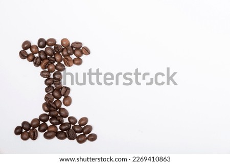 I is a capital letter of the English alphabet made up of natural roasted coffee beans that lie on a white background. Plenty of space to put text or pictures, top view and studio photography.