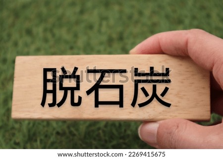 A person holding a building block written as coal phase-out.
Translation:coal phase out.