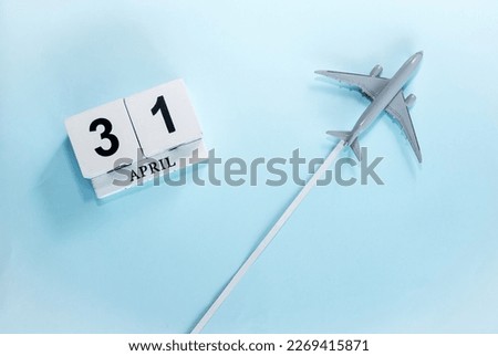 April calendar with number  31. Top view of a calendar with a flying passenger plane. Scheduler. Travel concept. Copy space.
