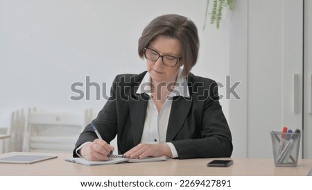 Stressed Old Senior Businesswoman Trying to Write at Work Royalty-Free Stock Photo #2269427891