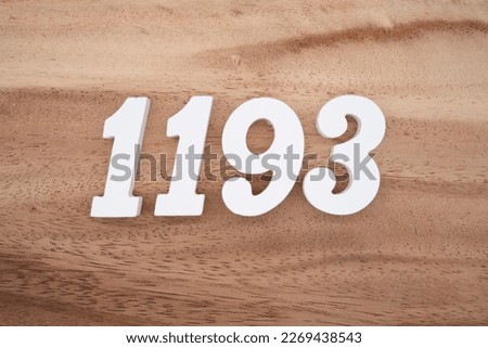 White number 1193 on a brown and light brown wooden background.