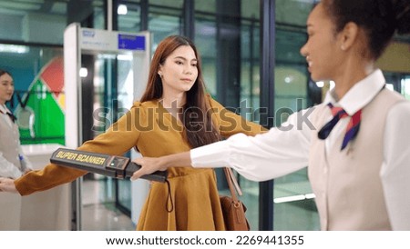 Security agent at airport check in gate with metal detector and scanner to passenger going on trip to terminal entrance Royalty-Free Stock Photo #2269441355