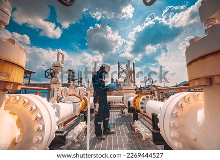 Male worker inspection at steel long pipes and pipe elbow in station oil factory during refinery valve of visual check record pipeline tank oil and gas industry Royalty-Free Stock Photo #2269444527