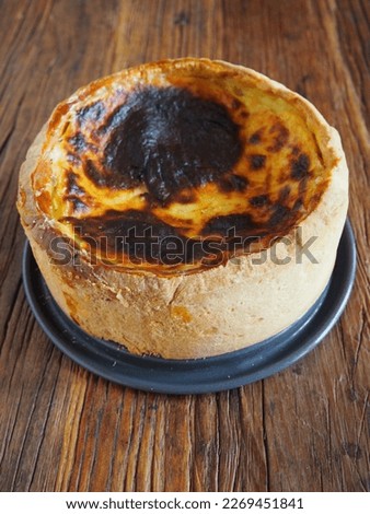French custard tart (flan pâtissier) isolated on a rustic wooden table, vertical picture