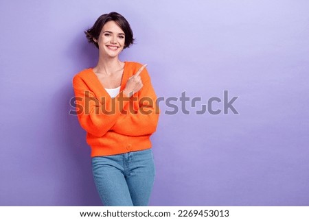 Photo of funny adorable woman wear orange cardigan pointing finger empty space isolated violet color background
