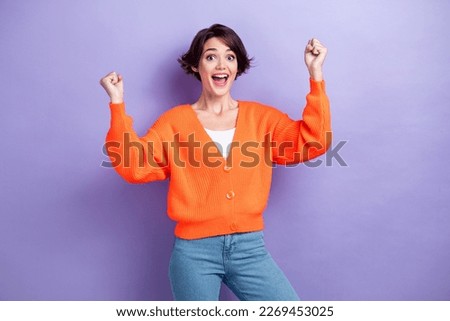 Photo of funny lucky woman wear orange cardigan shouting rising fists isolated violet color background Royalty-Free Stock Photo #2269453025