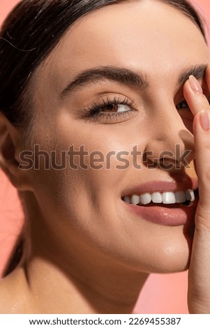 close up view of happy young woman with flawless makeup isolated on pink Royalty-Free Stock Photo #2269455387