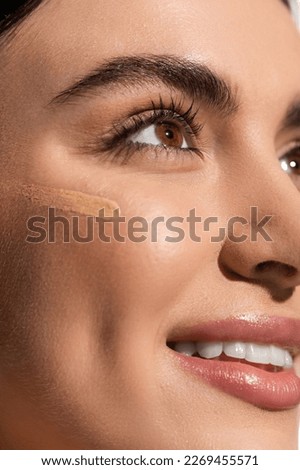 makeup foundation smudge on face of happy young woman with soft skin