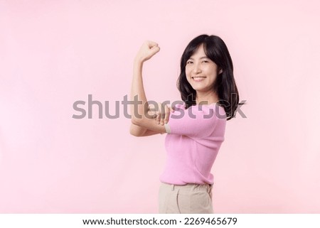 Portrait young asian woman confident and proud showing strong muscle strength arms flexed posing, feels about her success achievement. Women empowerment, equality, healthy strength and courage concept Royalty-Free Stock Photo #2269465679