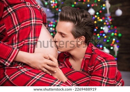 A man kneels before his wife and kisses her pregnant belly. Royalty-Free Stock Photo #2269488919