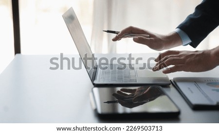 Person typing on laptop keyboard, businessman working on laptop, he is typing messages to colleagues and making financial information sheet to sum up the meeting. Royalty-Free Stock Photo #2269503713