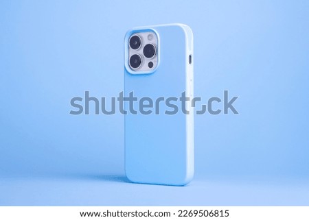 iPhone 14 and 13 Pro Max in light blue case back side view isolated on blue background, phone cover mock up in monochrome colours