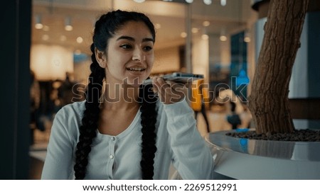 Young arabian woman girl shopper send voice message record audio speech talk on speakerphone activate sound app use ai assistance female businesswoman speak phone cell connection communicating online Royalty-Free Stock Photo #2269512991