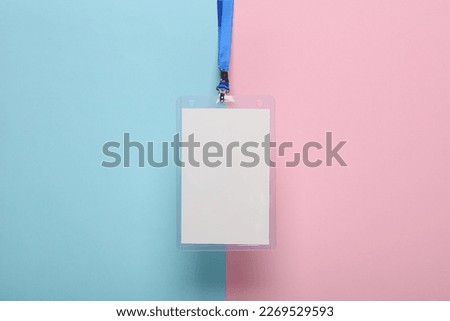 Empty white ID card badge mockup with blue belt on pink blue background. Staff identity name tag. Space for text and design. Top view. Flat lay