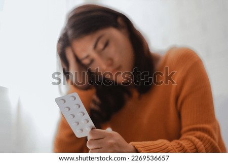 Woman self-medicates at home, reads medication instructions. Medical care at home. Illness and treatment concept Royalty-Free Stock Photo #2269536657