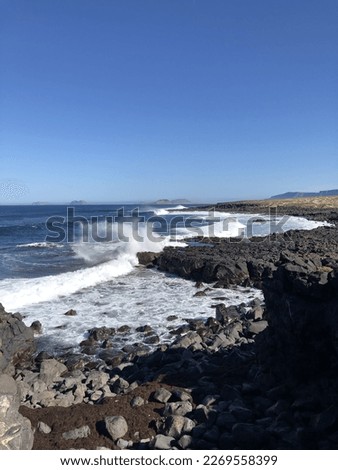 Ocean view background. Water splash from waves on rocky beach. Lanzarote island vertical wallpaper.