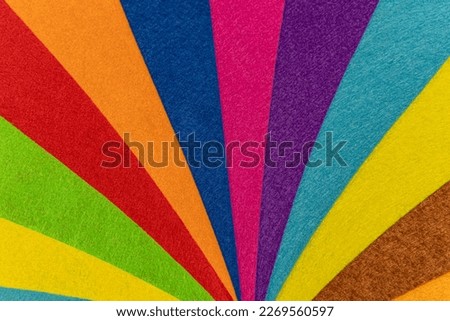 Texture created with overlapping pieces of felt creating a multicolored rainbow of curved lines that look like a circus tent