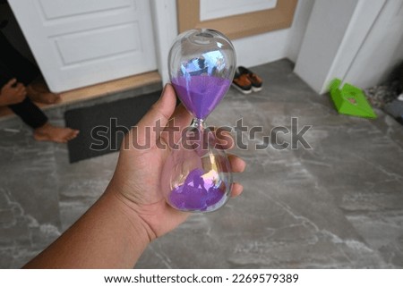 glass hourglass with purple sand
