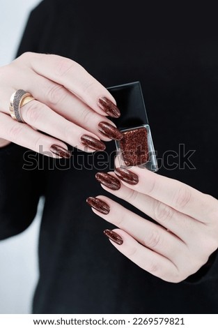 Female hands with long nails and dark red nail polish