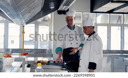 Asian male chef wearing a white hat. I'm recommending Teaching cooking to students It's in the university's cooking class. in teaching Thai cooking