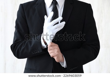 Business man with no face wearing white glove Royalty-Free Stock Photo #2269603059