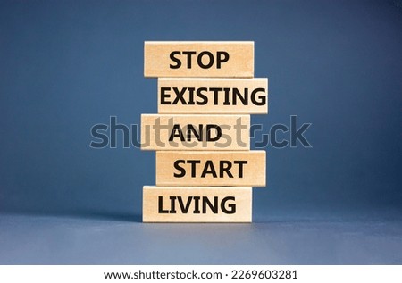 Stop existing start living symbol. Concept words Stop existing and start living on wooden blocks. Beautiful grey table grey background. Business Stop existing start living concept. Copy space. Royalty-Free Stock Photo #2269603281
