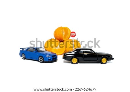 A photo after some edits, 2 toy cars try to reach oranges fruit. A concept of not to eat too much even if it is a healthy fruit.