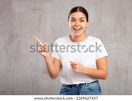 Shot of smiling young woman gesturing in casual clothes indoors